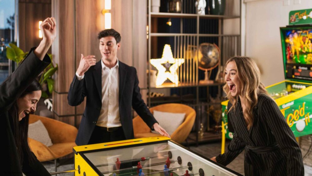 Colleghi che giocano a calcio ballilla nella gaming area